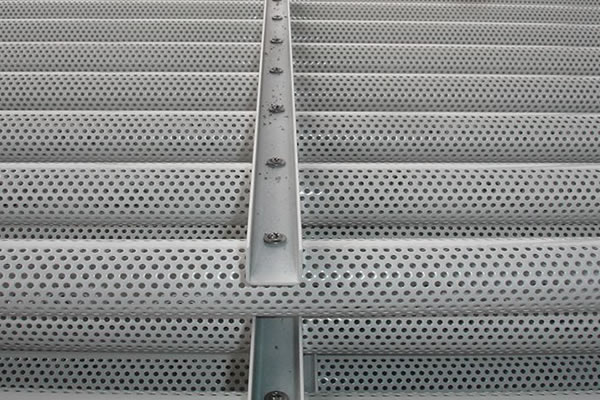 Perforated steel panels for wind resisting cladding